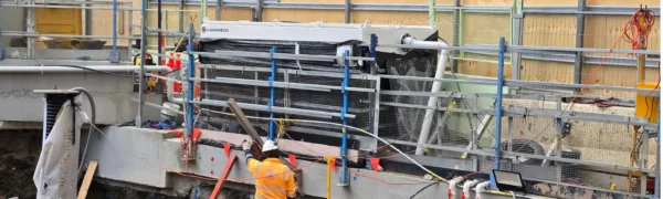 Holding tank separating solids from water before discharge to reduce site runoff and protect surrounding areas