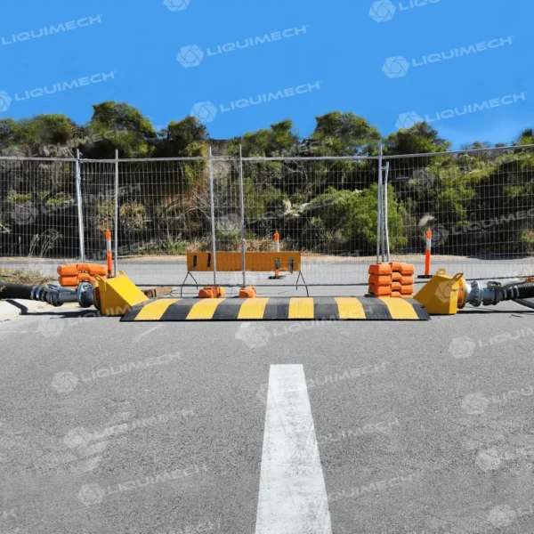 Liquimech road ramp hose assembly site setups, shielding layflat and suction hoses from damage.