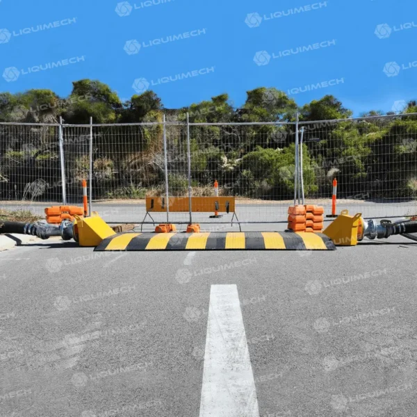 Liquimech road ramp hose assembly site setups, shielding layflat and suction hoses from damage.